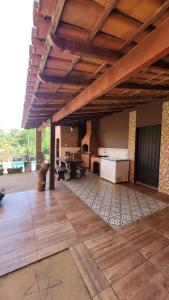 a large room with a wooden floor and a kitchen at Chácara super aconhegante in Vila Velha