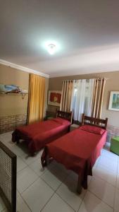 a bedroom with two beds with red covers in it at Chácara super aconhegante in Vila Velha