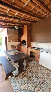 a large kitchen with a table and a stove at Chácara super aconhegante in Vila Velha