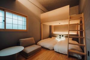 a bedroom with a bunk bed and a chair at 無垢　入船の宿 in Kure