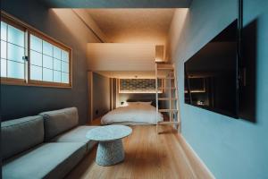 a room with a couch and a bed and a table at 無垢　入船の宿 in Kure