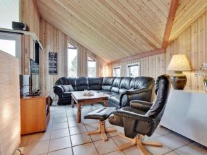 a living room with a leather couch and a table at Holiday Home Aisa - all inclusive - 10-5km from the sea by Interhome in Oksbøl