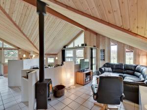 a living room with a couch and a stove at Holiday Home Aisa - all inclusive - 10-5km from the sea by Interhome in Oksbøl