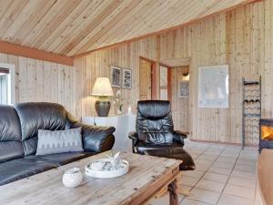 a living room with a leather couch and a table at Holiday Home Aisa - all inclusive - 10-5km from the sea by Interhome in Oksbøl