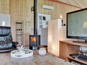 a living room with a fireplace and a television at Holiday Home Aisa - all inclusive - 10-5km from the sea by Interhome in Oksbøl