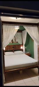 a bedroom with a canopy bed with white curtains at Panana Irida in Mérikhas