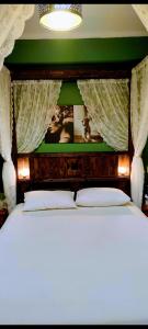 a bed with a wooden headboard with curtains above it at Panana Irida in Mérikhas