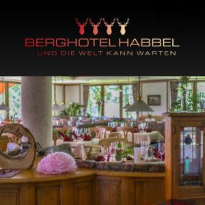 una señal para un restaurante con mesas y sillas en Berghotel Habbel und die Welt kann warten, en Cobbenrode