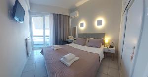 a bedroom with a bed with two towels on it at Hotel Avra in Preveza