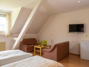 1 dormitorio con 1 cama y TV en la pared en Weingut / Gästehaus Gerlach, en Ürzig