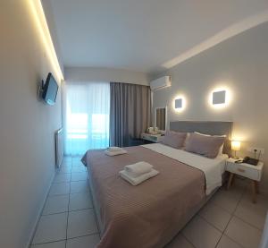 a bedroom with a large bed with two towels on it at Hotel Avra in Preveza