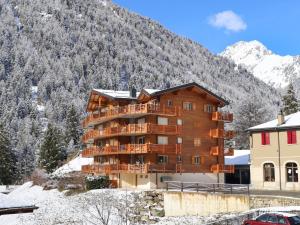 a large wooden building with a mountain in the background at Apartment Les Combins apt- 23 by Interhome in Champex