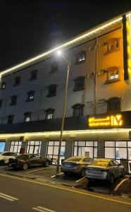 uma luz de rua em frente a um edifício com carros estacionados em Maro Hotel em Abha