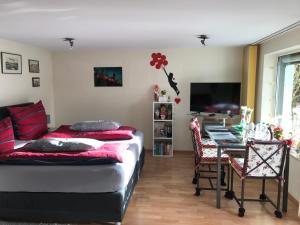 - une chambre avec un lit, une table et une télévision dans l'établissement Apartment Christine, à Altena