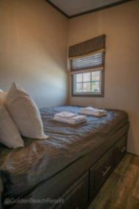 Un dormitorio con una cama con dos almohadas y una ventana. en 3 Bedroom Waterview Cottage 5B, en Roseneath