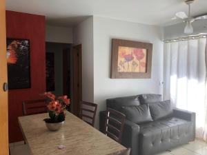 ein Wohnzimmer mit einem Tisch und einem Sofa in der Unterkunft THERMAS DO BANDEIRANTE in Caldas Novas