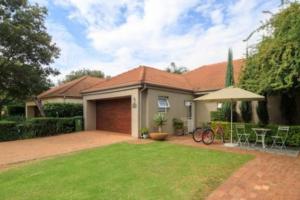 a house with a garage and a lawn at Lovely Family Home / Pecanwood Golf Estate in Hartbeespoort