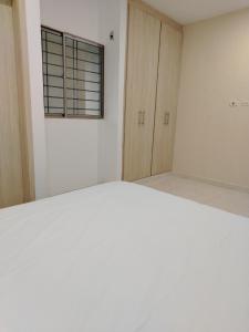Dieses weiße Zimmer verfügt über ein Fenster und ein Bett. in der Unterkunft Oasis Olmos in Cereté