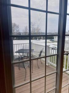 Sodus Point的住宿－Etta Belle Condo 1，阳台配有桌椅,享有风景。
