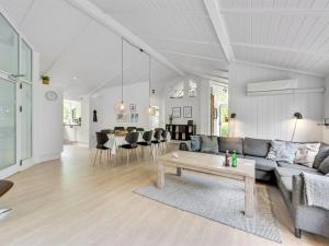 ein Wohnzimmer mit einem Sofa und einem Tisch in der Unterkunft Holiday Home Liviana - all inclusive - from the sea by Interhome in Blåvand