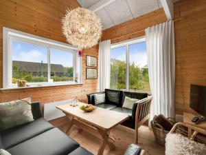 ein Wohnzimmer mit einem Kronleuchter und einem Tisch in der Unterkunft Holiday Home Oddger - all inclusive - 250m to the inlet by Interhome in Skjern