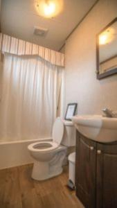 une salle de bain avec des toilettes blanches et un lavabo dans l'établissement 2 Bedroom Waterfront Cottage Cedar Point Cres 4, à Campbellford