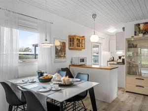 een keuken en eetkamer met een tafel en stoelen bij Holiday Home Westi - all inclusive - 650m to the inlet by Interhome in Hemmet
