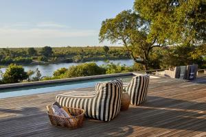 two chairs sitting on a deck with a view of a river at Ukuthula House in Hectorspruit