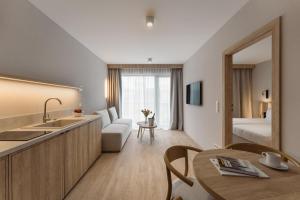 a hotel suite with a kitchen and a living room at Termy Karkonosze Resort & Spa in Staniszów