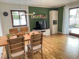 ein Esszimmer mit einem Tisch und einem TV in der Unterkunft Apartment Auszeit by Interhome in Oy-Mittelberg