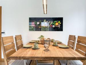 a wooden table with chairs and a painting on the wall at Apartment Auszeit by Interhome in Oy-Mittelberg +16 photos