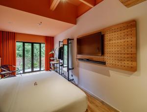 a bedroom with a bed and a flat screen tv at The Somos Bold Hotel in Medellín