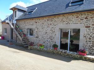 a brick house with a person sitting in a window at Les Gites de Kerdurod in Guidel