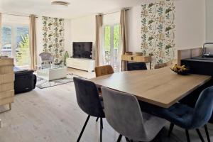 uma sala de estar com uma mesa de madeira e cadeiras em L'HARMONIE, Appartement 2 chambres proche du lac, calme et lumineux em Annecy