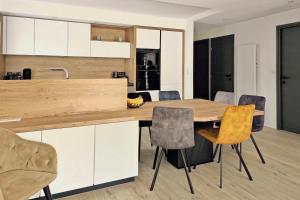 uma cozinha com uma mesa de madeira e cadeiras em L'HARMONIE, Appartement 2 chambres proche du lac, calme et lumineux em Annecy
