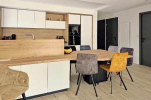 a kitchen with a wooden table and chairs at L'HARMONIE, Appartement 2 chambres proche du lac, calme et lumineux in Annecy