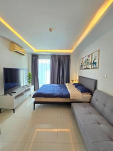 een grote slaapkamer met een bed en een bank bij Laguna beach condo resort 3 maldives pattaya top pool view ลากูน่า บีช คอนโด รีสอร์ต 3 พัทยา in Jomtien Beach