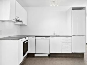 a white kitchen with white cabinets and a sink at Apartment Viljo - all inclusive - 100m from the sea by Interhome in Hals
