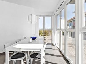 un comedor blanco con una mesa y sillas blancas en Apartment Viljo - all inclusive - 100m from the sea by Interhome en Hals