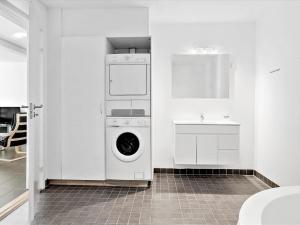 - une cuisine blanche avec un lave-linge et un évier dans l'établissement Apartment Viljo - all inclusive - 100m from the sea by Interhome, à Hals