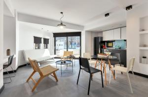 MichELe Luxury apartments by Smaris Collection في ماليا: مطبخ وغرفة معيشة مع طاولة وكراسي