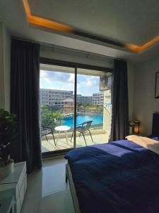 1 dormitorio con cama y vistas a un balcón en Laguna beach condo resort 3 maldives pattaya top pool view ลากูน่า บีช คอนโด รีสอร์ต 3 พัทยา en Jomtien Beach