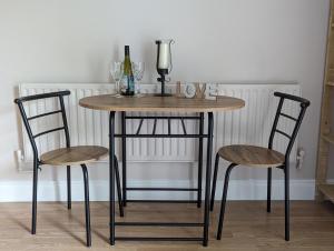un tavolo con due sedie e una bottiglia di vino di Cozy Getaway in Bunratty a Clarecastle