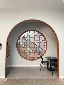 a room with a circular window and a table at HAKKA Wellness Residence in Samut Songkhram