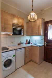a kitchen with a washing machine and a washer at STUDIO SPYROS in Kanoni