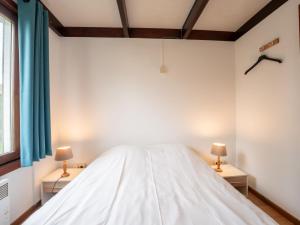 1 dormitorio con 1 cama blanca y 2 mesitas de noche en Holiday Home Edelweiss by Interhome, en De Haan