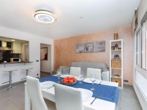 Un comedor y una sala de estar con mesa y sillas. en Apartment Pinos by Interhome, en Port de la Selva