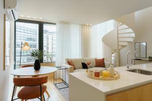 波多的住宿－Feel Porto Corporate Housing Boavista，厨房以及带沙发和桌子的客厅。