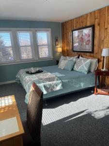 1 dormitorio con cama, mesa y ventanas en Chateau Country Inn and Captain's Cottage, en Clayton