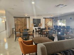 uma sala de espera com mesas e cadeiras e uma cafetaria em Holiday Inn Express & Suites Clermont SE - West Orlando, an IHG Hotel em Orlando